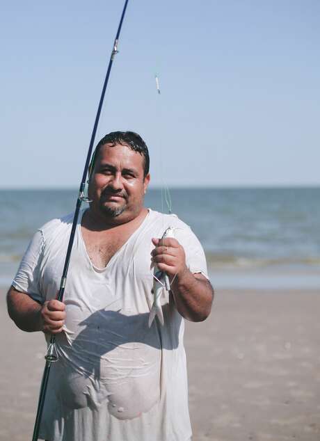 Angel Varges shows off the fish he caught at El Jardin Beach. Photo: Elizabeth Conley/Staff Photographer / © 2020 Houston Chronicle