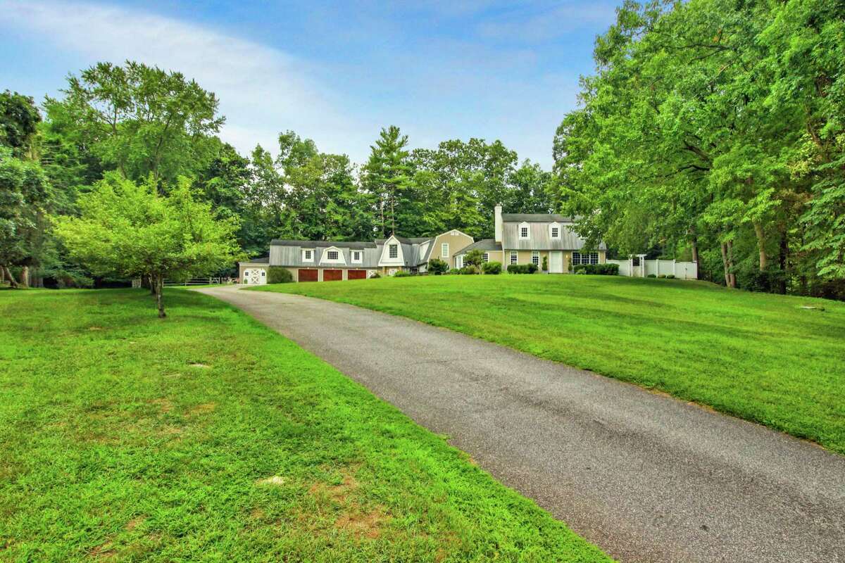 The taupe-colored colonial farmhouse at 61 River Road in the Lower Weston neighborhood sits on a 1.83-acre former equestrian estate. Also found in this backyard are fruit trees and a hot tub, and there is room for an in-ground swimming pool. Until or unless the next owners install a pool, aquatic recreation will have to take the form of fishing, which is possible directly across the street Keene Park where there is access to the Saugatuck River. The park also has a playground. Ample parking for family and guests is available in the driveway comprising pavement, cobblestones and crushed stone circles in front of the attached three-car garage. Inside, the formal living room is large enough to accommodate a grand piano in addition to the sitting area. The formal dining room is equally spacious. It has chair railing and wide-planked hardwood flooring.