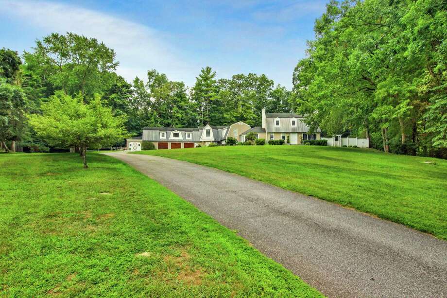 The taupe-colored colonial farmhouse at 61 River Road in the Lower Weston neighborhood sits on a 1.83-acre former equestrian estate.