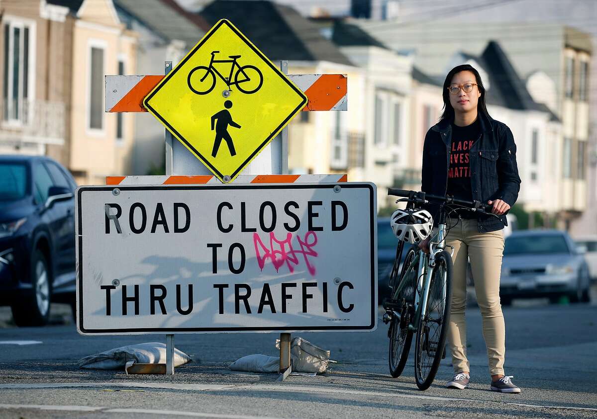 Janice Li, with the SF Bicycle Coalition, stops at a barricade designating 41st Avenue in the Sunset district a "slow streets" thoroughfare restricted to bicycles, pedestrians and local traffic only, in San Francisco, Calif. on Tuesday, Sept. 15, 2020.