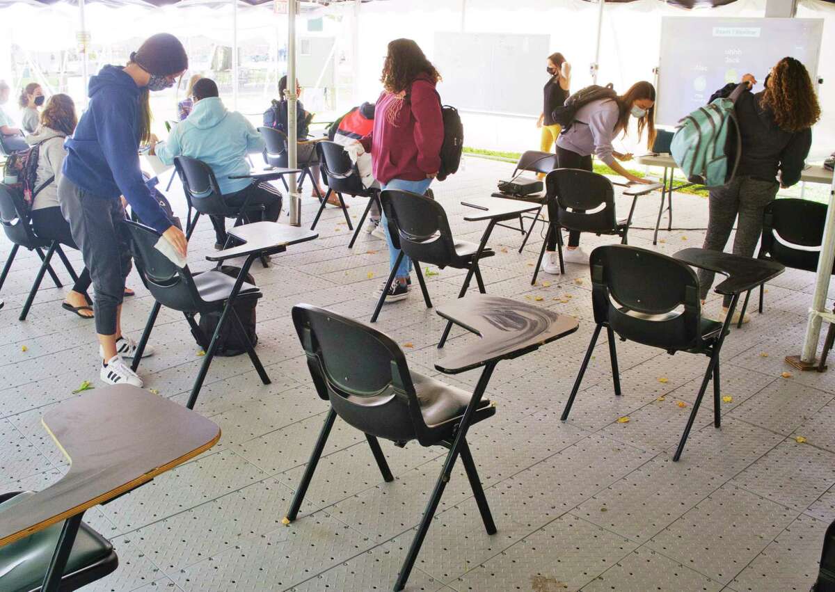 Siena College students disinfect the desks they were sitting at as a class held outdoors ends on Wednesday, September 16, 2020, in Loudonville, N.Y. (Paul Buckowski/Times Union)