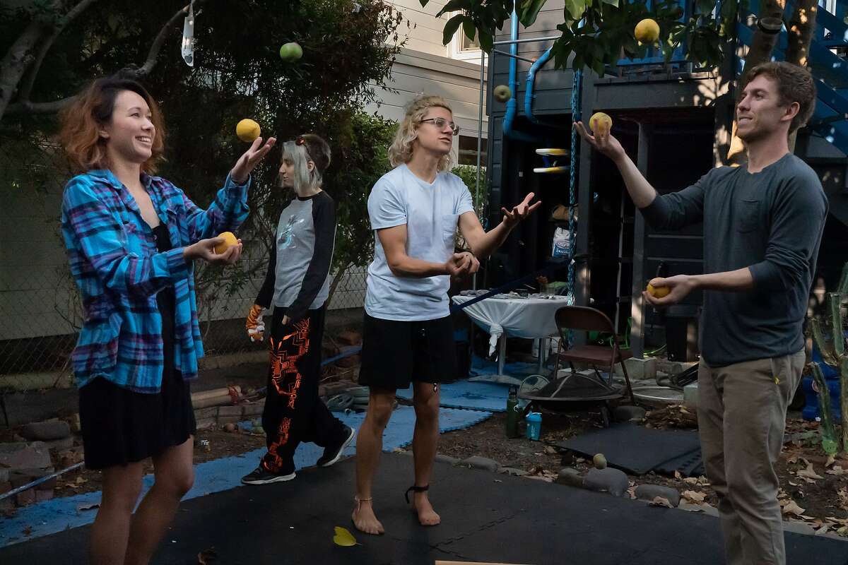Caitlyn Kenney, Simon Wisdom and Armand Matossian juggle as Ninoa Knangar walks by at the Manor of Being House on Tuesday, Sept. 15, 2020 in San Francisco, Calif. Eleven international people share the home with occupations that includes tech, mathematics, music and art.