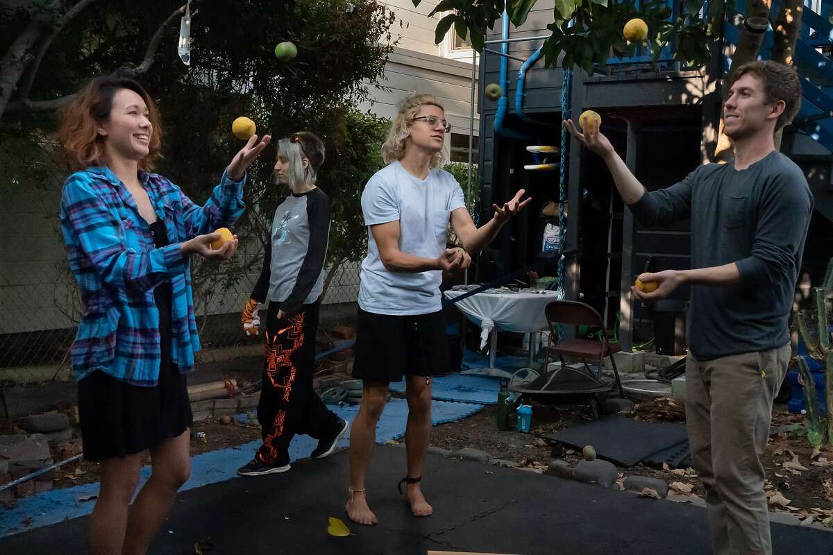 Manor of Being residents Caitlin Kenney (left), Simon Wisdom and Armand Matossian juggle as Ninoa Kamangar walks by at the Mission District house.