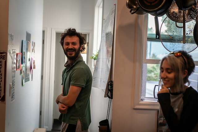 Giray Gintel and Ninoa Kamangar spend a moment in the kitchen at the Manor of Being in the Mission District. The communal living space has 11 roommates.