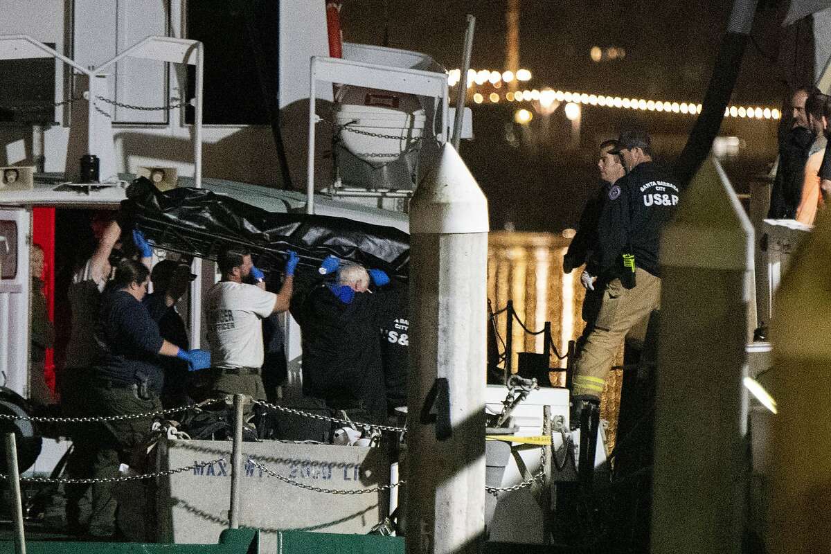 Local law enforcement along with search and rescue teams help unload the bodies of those who died in a diving boat fire, in Santa Barbara, Calif.  All 33 passengers and one crew member died in the pre-dawn fire on Sept. 2, 2019. (AP Photo/Christian Monterrosa, File)