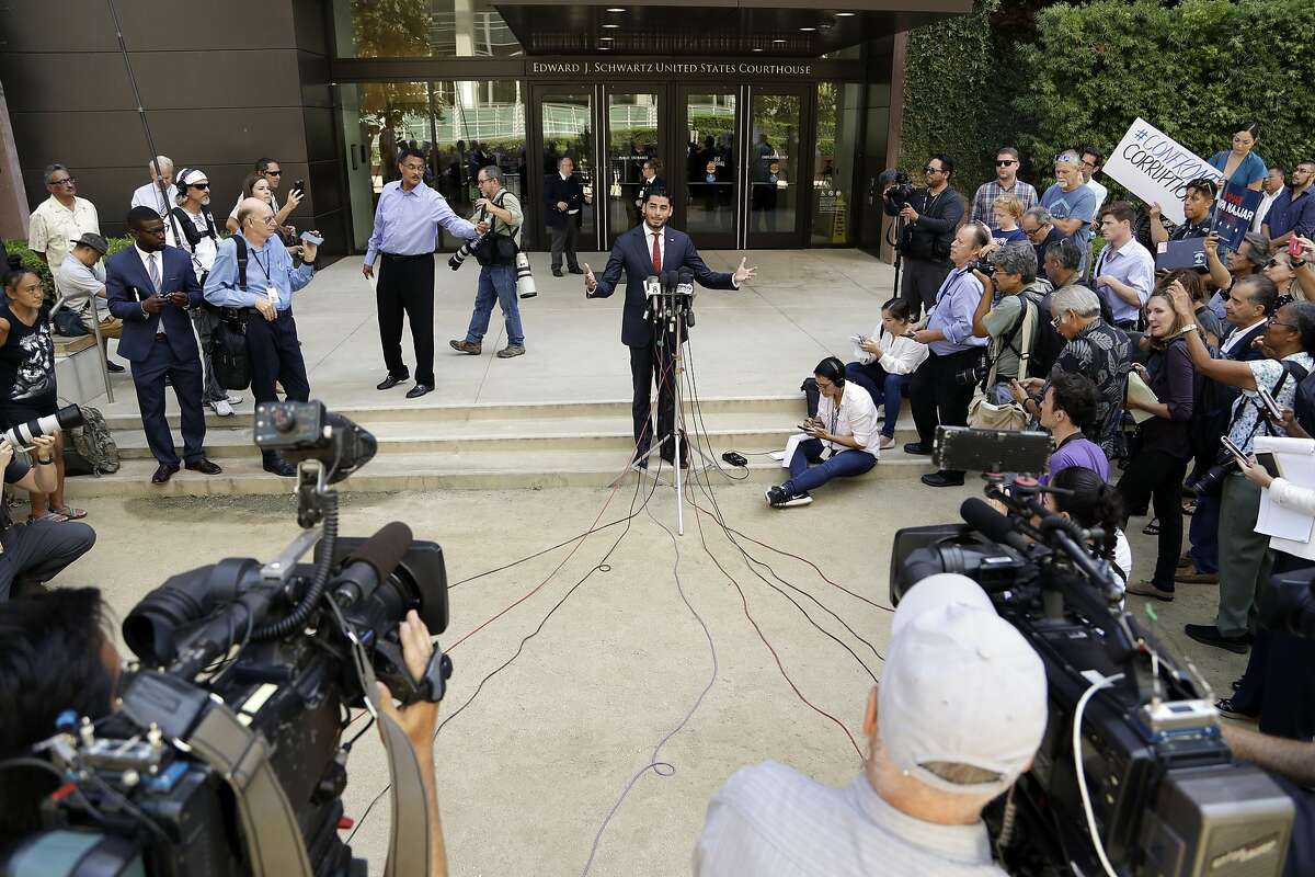 Democratic congressional candidate Ammar Campa-Najjar, center, who is running against U.S. Rep. Duncan Hunter, speaks in front of a federal courthouse as reporters wait for the end of an arraignment for Hunter and his wife Thursday, Aug. 23, 2018, in San Diego. Hunter and his wife Margaret pleaded not guilty Thursday to charges they illegally used his campaign account for personal expenses. (AP Photo/Gregory Bull)