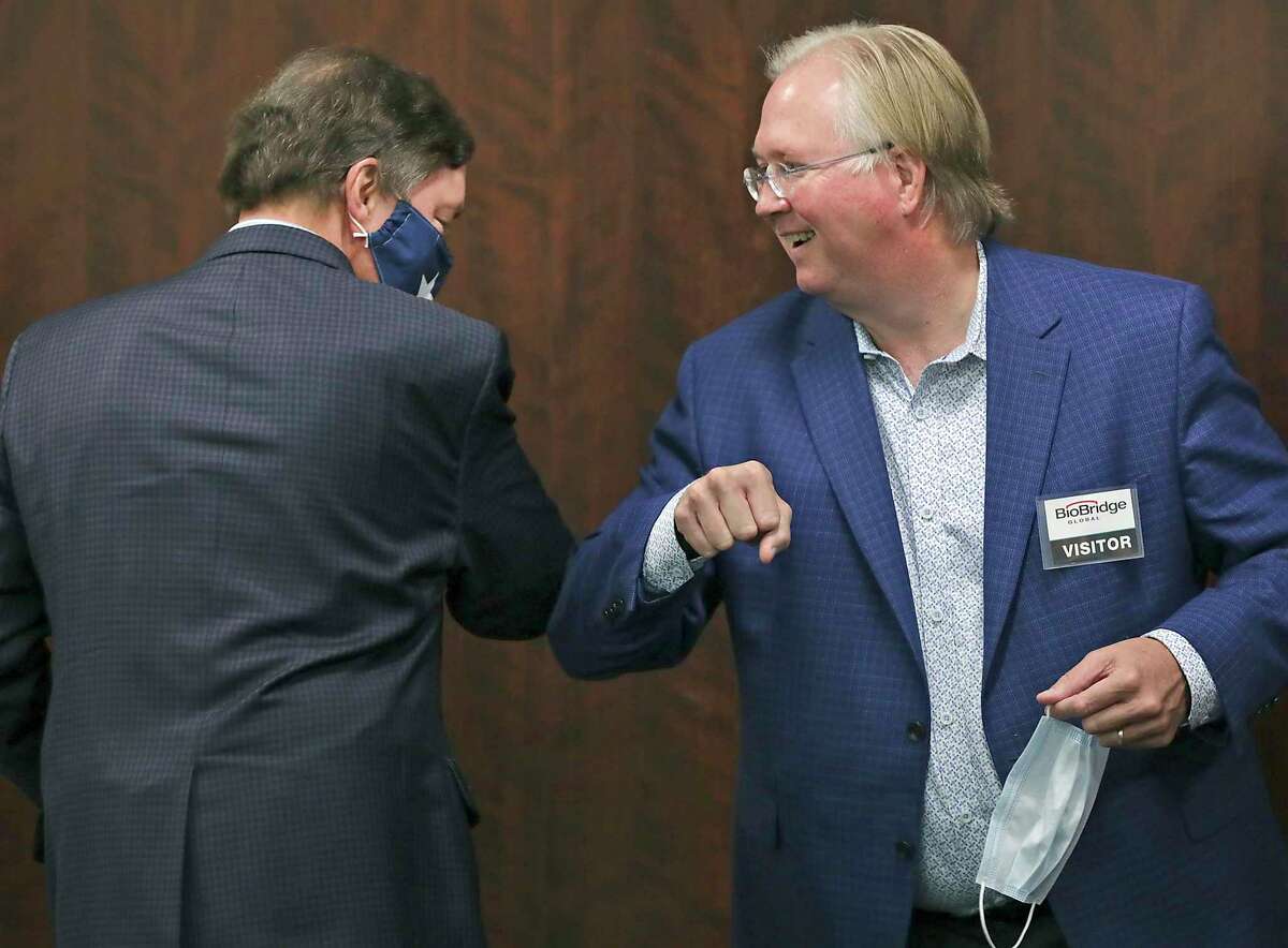 Graham Weston, right, chairman of Community Labs, bumps elbows with Bruce Bugg Jr., vice chairman of Community Labs, a new nonprofit that they said will deliver faster results of coronavirus tests in San Antonio. They spoke at a news conference Thursday, Sept. 17, 2020.