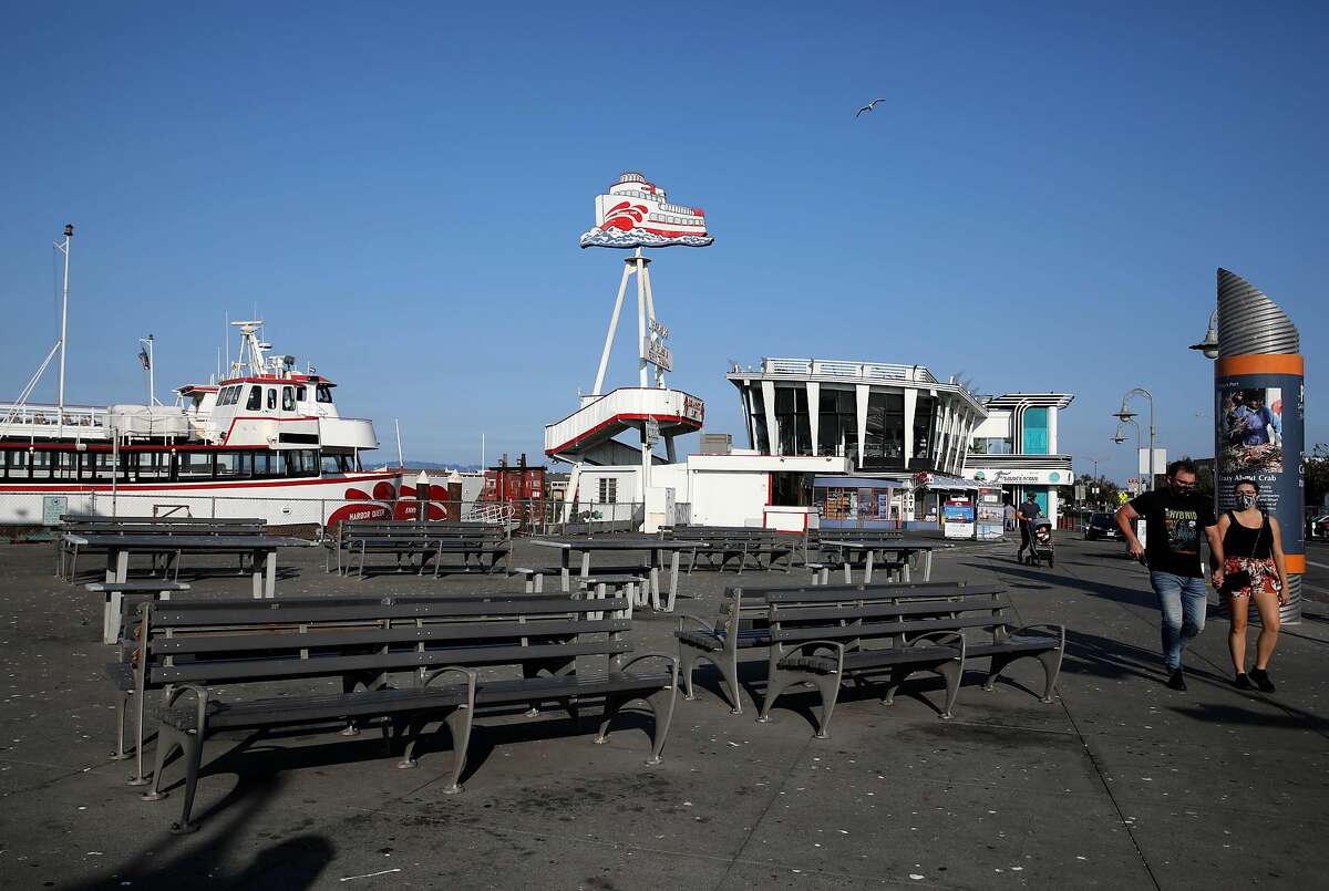 People walk at Fisherman's Wharf on Wednesday, September 16, 2020, in San Francisco, Calif. The area has been transformed by the lack of crowds and emptiness created in the wake of the COVID pandemic.