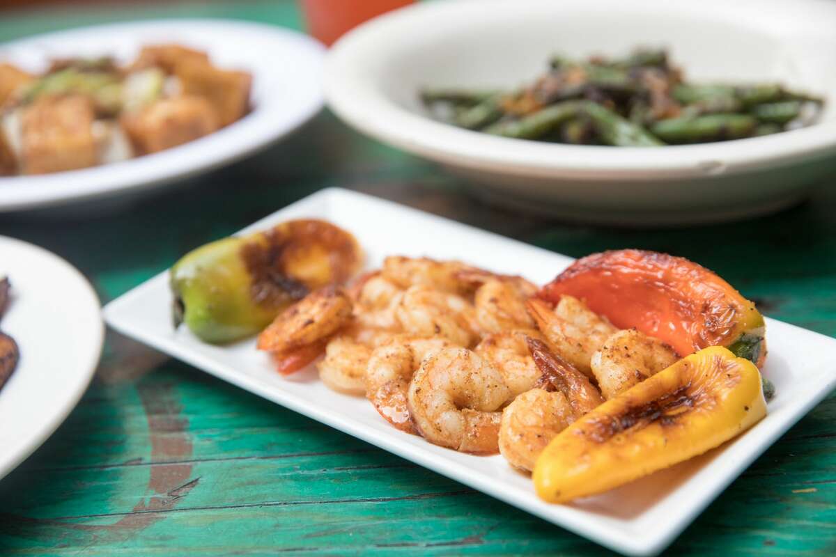 Kingston 11 Cuisine dishes include Wild Gulf Shrimp (foreground), Black Pepper Tofu, Sauteed string beans, and Plantains with vegan black bean sauce and sour cream. The restaurant, which features Jamaican food, is one of several participating in Oakland Restaurant (and More) Week in 2021.