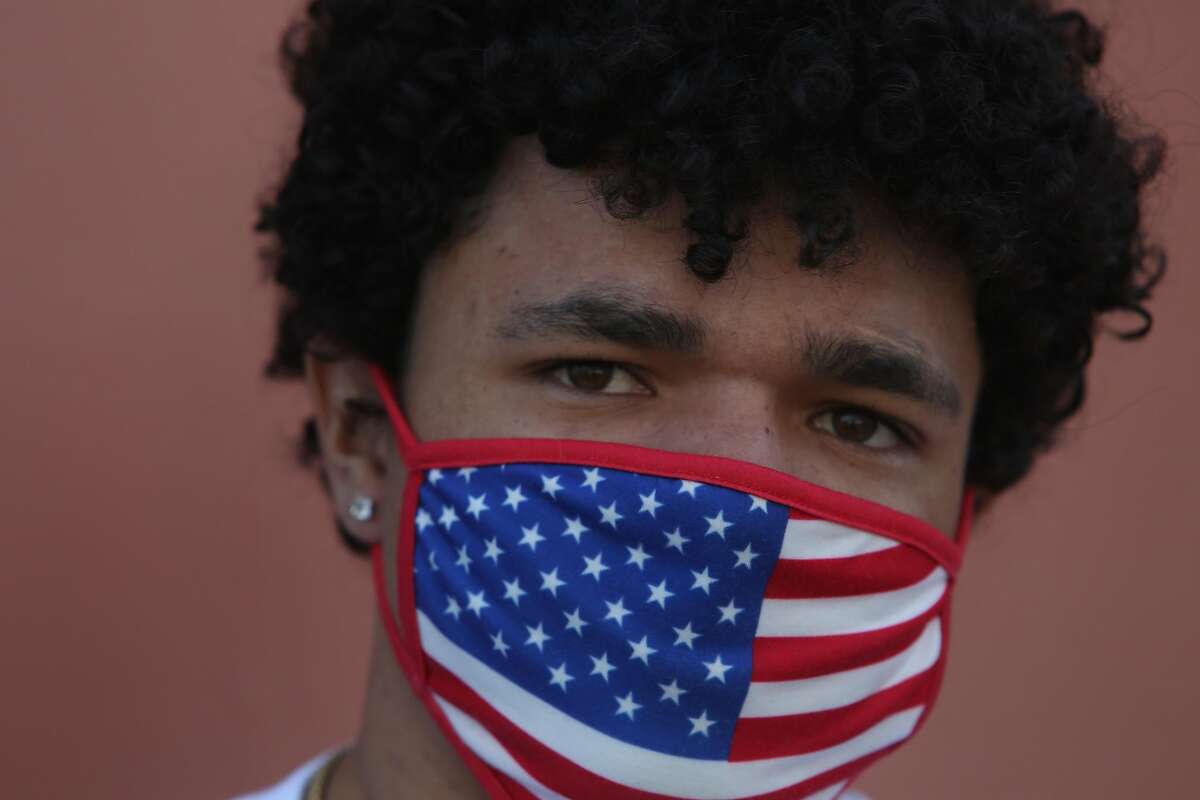 Reece of Oakland wears an facemask decorated with the American flag at the March for Equity on Saturday, July 4, 2020 in San Francisco, Calif.