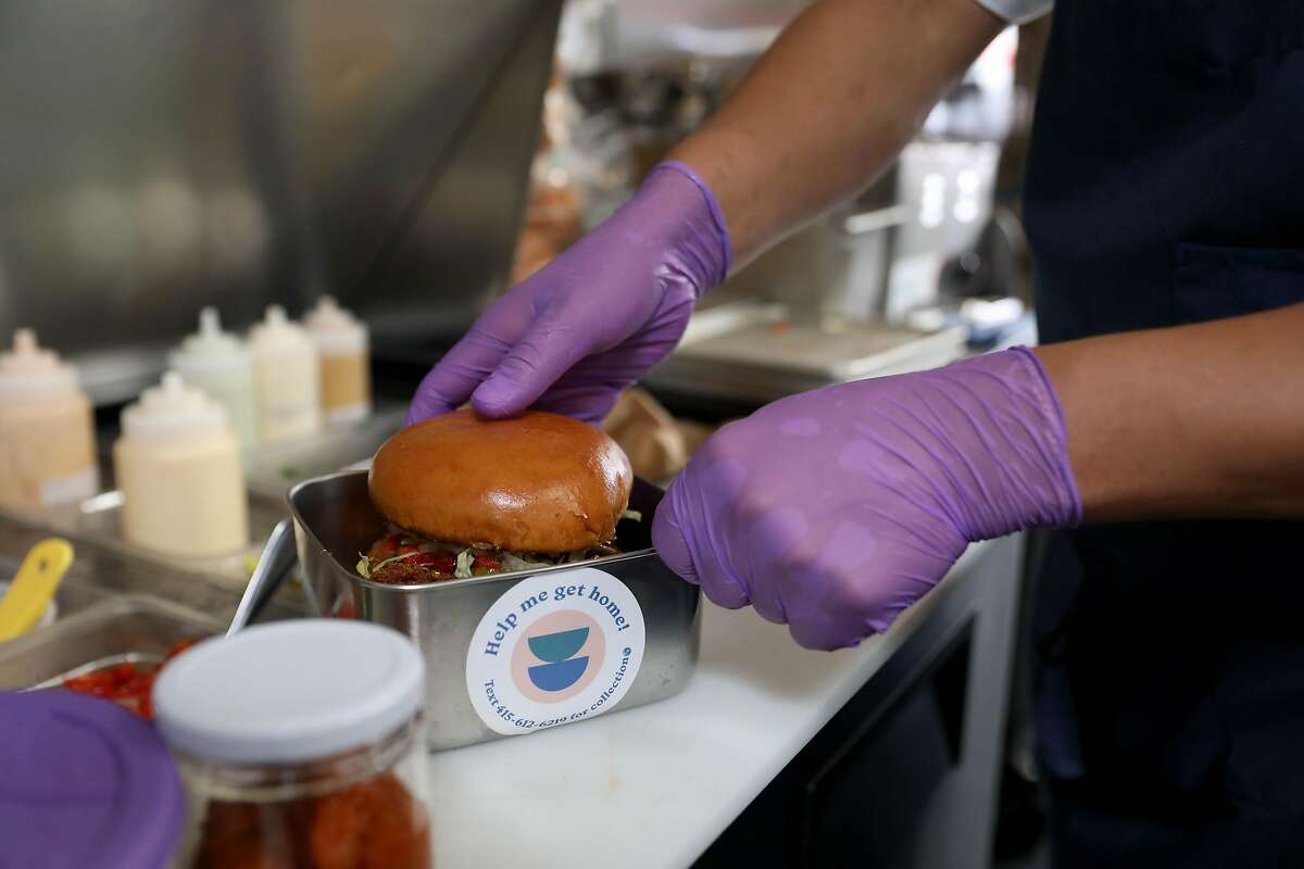 Rogelio Hernandez places a burger into a Dispatch Goods stainless steel container at Square Pie Guys on Friday, September 18, 2020, in San Francisco, Calif. People are ordering more takeout than ever before, which also means they're throwing out a lot of single-use containers. It's been a blow to the Bay Area's zero waste movement, which was growing earlier this year thanks to several new city ordinances and has since seemingly screeched to a halt. But the pandemic hasn't stopped Lindsey Hoell, the founder of San Francisco startup Dispatch Goods, from trying to bring a radical, zero-waste solution to the takeout world. Her vision of the future includes another bin at people's homes that sits next to trash and recycling for reusable takeout containers. People would order delivery from their favorite restaurant, request Dispatch packaging and toss it in the bin, and then Dispatch would pick up the containers, wash them and bring them back to restaurants. Dispatch already started this model during the pandemic with a few San Francisco restaurants, but the scope is about to get much larger with a new delivery pilot with Square Pie Guys on Doordash and another, three-year pilot with the city of Alameda.