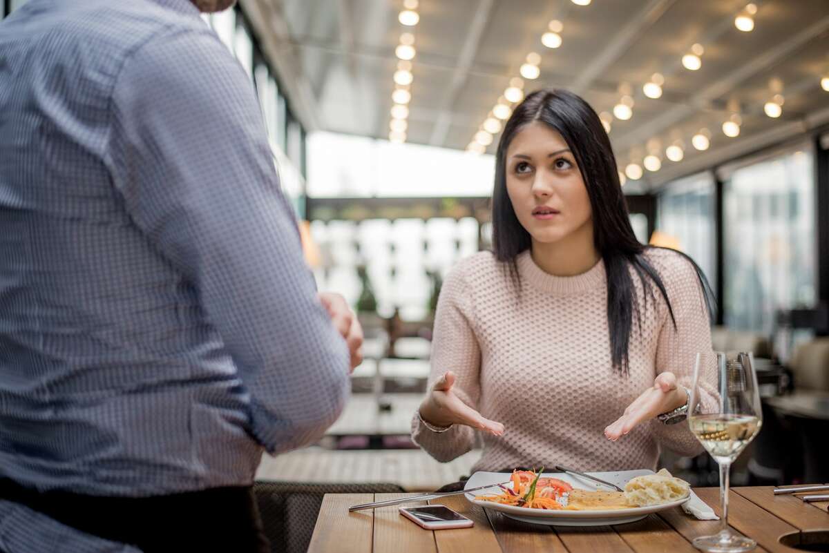Portrait of woman complaining about food quality and taste in restaurant.
