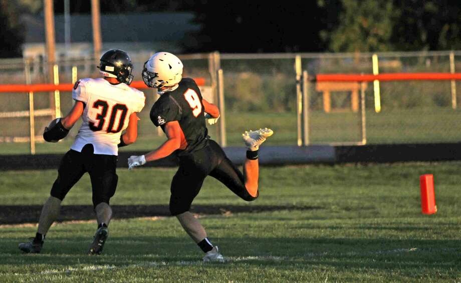 Ubly’s Carson Heleski (30) runs it into the end zone just ahead of Harbor Beach’s Mason Booms to put the Bearcats up 7-0 early in the first quarter in the season opener at Harbor Beach.