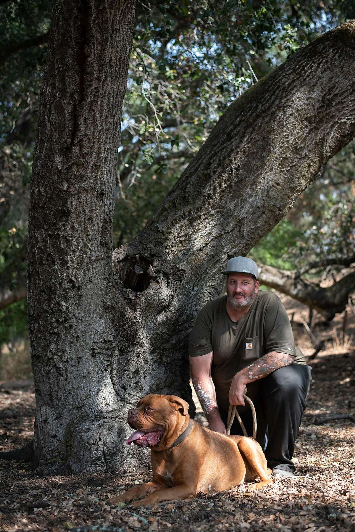Chris Woolf poses with his 4-year-old mastiff Sir Anthony Brutus Brewcephus II (BruTwo for short) in San Martin on Sept. 17, 2020. Woolf, a former Navy medic and Burning man ranger, waited until the last possible moment to pack up his truck and evacuate his home in Butte County after the North Complex Fire swept through the area. He does not know if his house has survived.