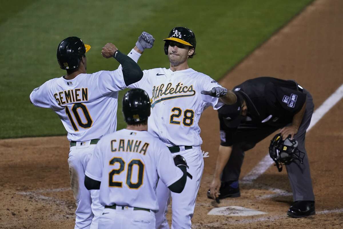 Oakland Athletics' Matt Olson (28) is greeted by Marcus Semien (10) and Mark Canha (20) after hitting a three-run home run off San Francisco Giants starting pitcher Logan Webb during the third inning of a baseball game Friday, Sept. 18, 2020, in Oakland, Calif. (AP Photo/Eric Risberg)