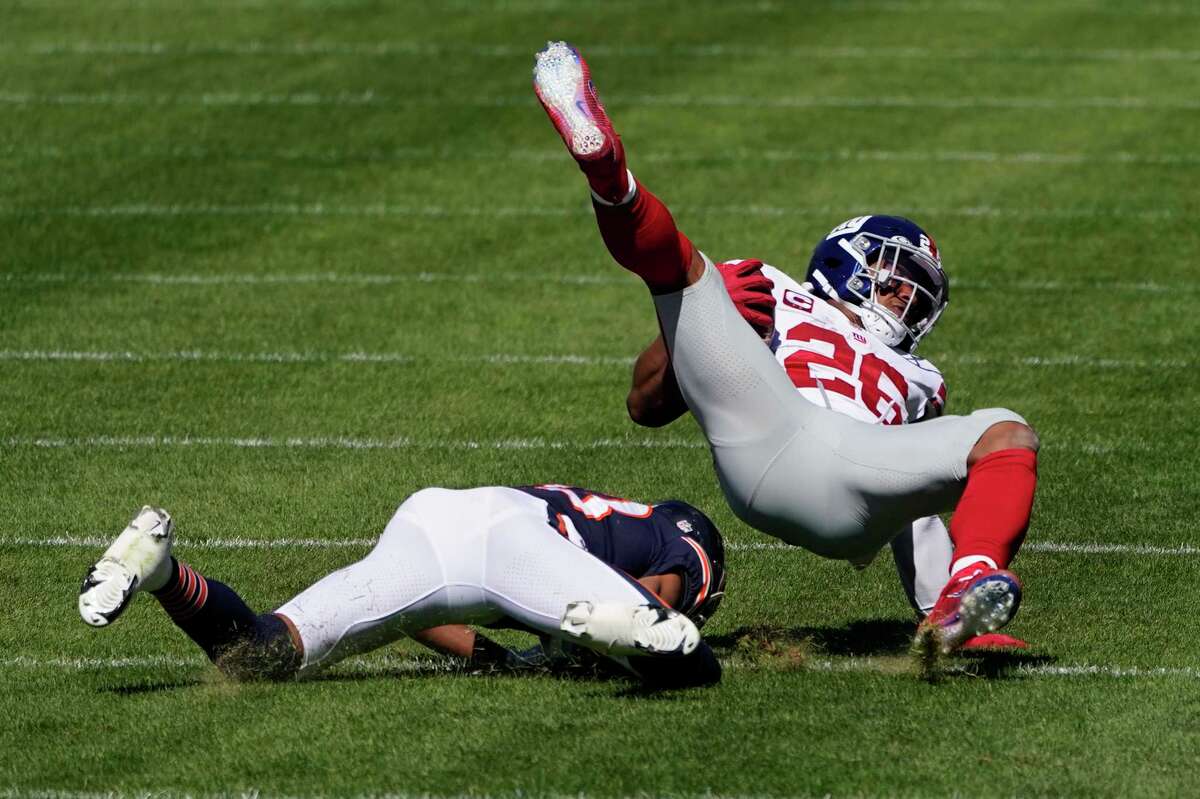 New York Giants running back Saquon Barkley (26) is brought down by Chicago Bears cornerback Kyle Fuller (23) during the first half of an NFL football game in Chicago, Sunday, Sept. 20, 2020. (AP Photo/Charles Rex Arbogast)