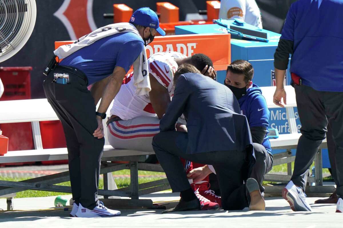New York Giants running back Saquon Barkley is attended to on the bench by medical staff after being injured against the Chicago Bears during the first half of an NFL football game in Chicago, Sunday, Sept. 20, 2020. (AP Photo/Nam Y. Huh)