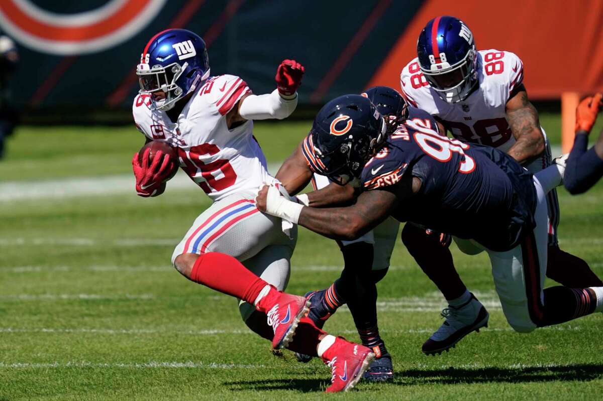 New York Giants running back Saquon Barkley (26) tries to break free from Chicago Bears defensive tackle John Jenkins (90) during the first half of an NFL football game in Chicago, Sunday, Sept. 20, 2020. (AP Photo/Charles Rex Arbogast)