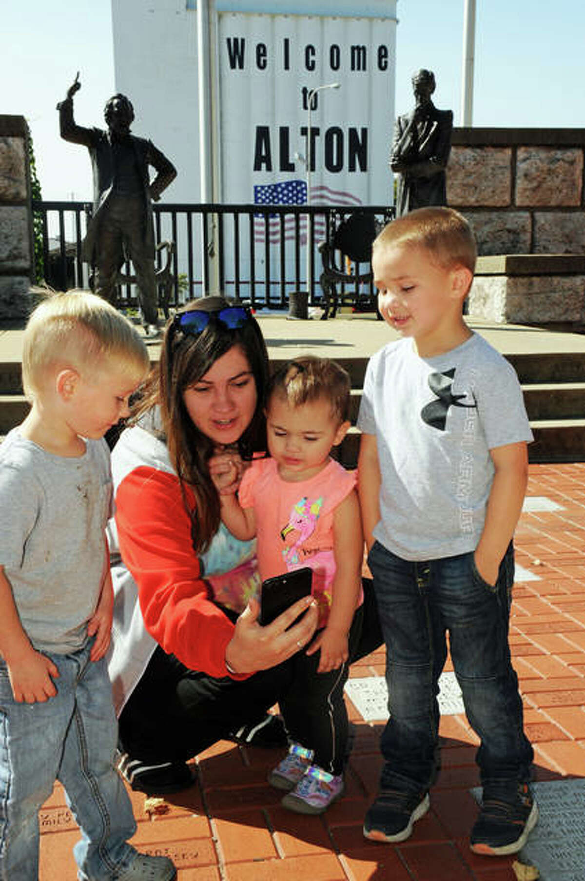 Members of the Schmidt and Herndon families look for clues at Lincoln Douglas Square during Saturday’s scavenger hunt.