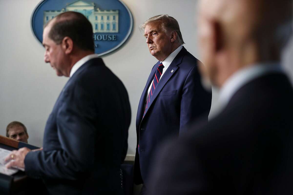 President Donald Trump listens as Human Services Secretary Alex Azar spoke at the White House in Washington, Aug. 23, 2020. A controversial guideline saying that people without COVID-19 symptoms didn’t need to get tested was reportedly not written by CDC scientists, and was posted to the CDC’s website in August by HHS officials. (Oliver Contreras/The New York Times)
