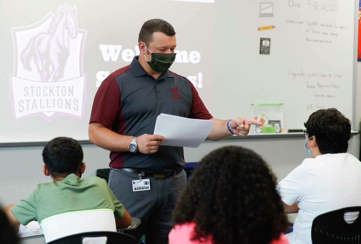 A seventh-grade history teacher instructs students at the start of class at Stockton Junior High School on the first day of in-person school Sept. 8.