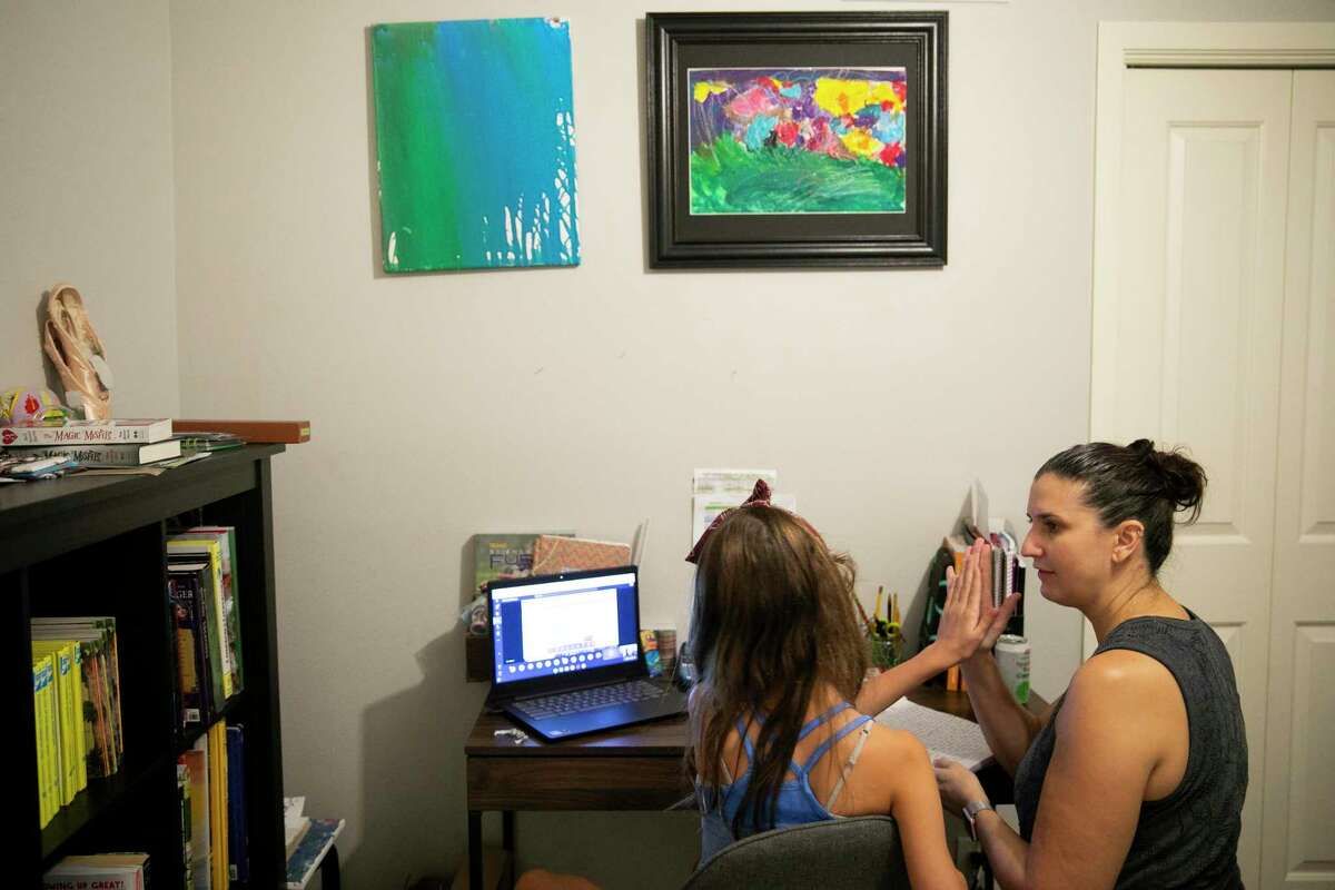 Sophia Sorena gives her mother, Amanda, a high five during virtual lessons in the Sorena home on Thursday Sept. 17, 2020.