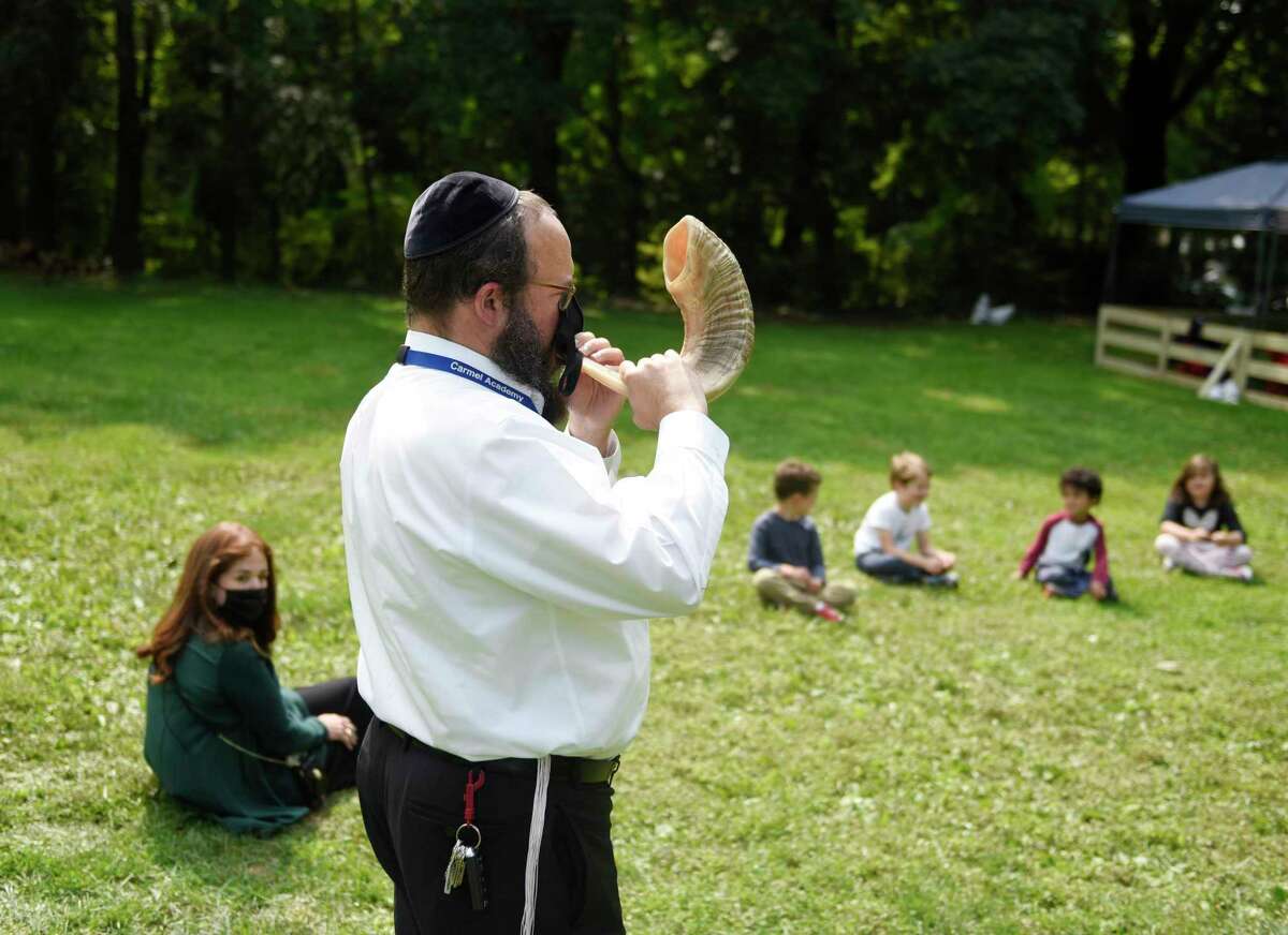 Rabbi Yossi Deren blows the shofar at the new Jewish school Tamim Academy in Greenwich, Conn. Tuesday, Sept. 15, 2020. Located at the location of the former Carmel Academy, the new school is an affiliate of Chabad Lubavitch Greenwich for preschool and kindergarten students.