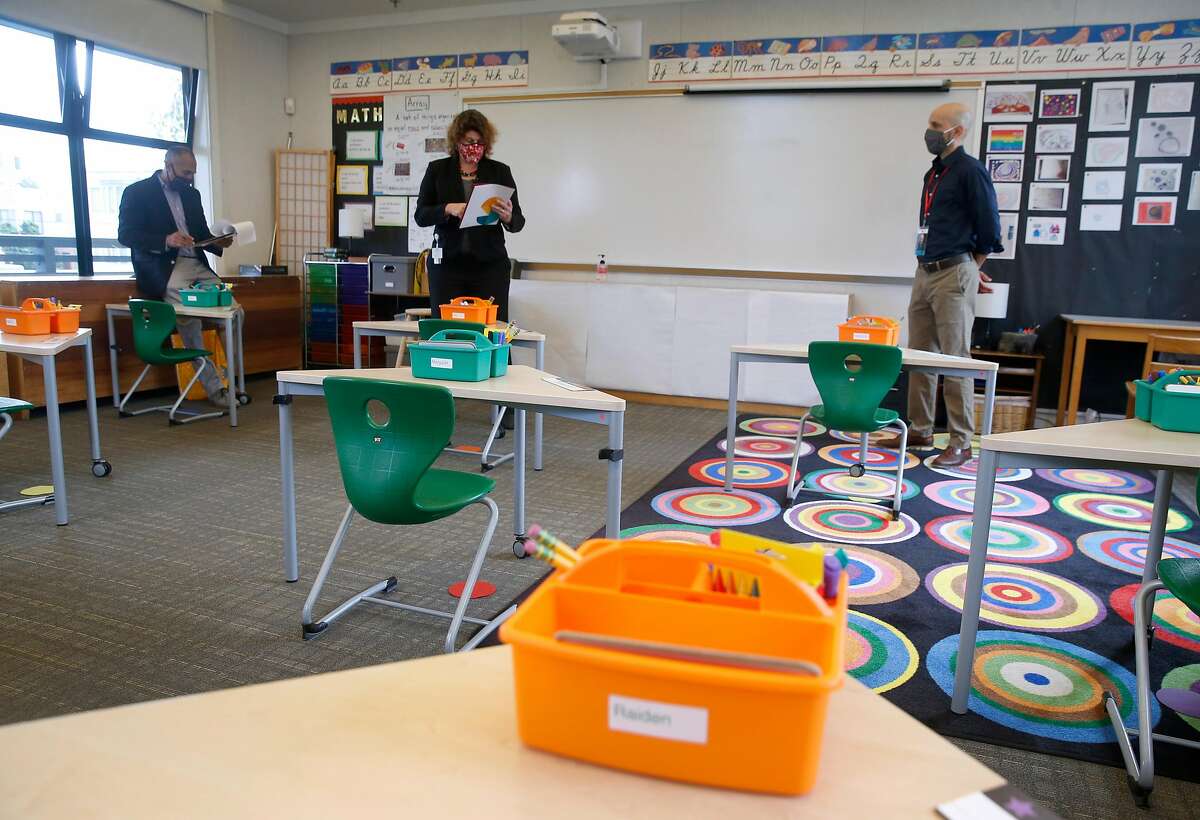 Head of School Steve Morris (right) leads a tour of a classroom for city inspectors Julian Vanales (left) and Ana Validzic at The San Francisco School before authorizing in-person learning on the campus in San Francisco, Calif. on Thursday, Sept. 17, 2020. The private school with 285 students enrolled is among the first school's in the city to apply for in-classroom instruction.