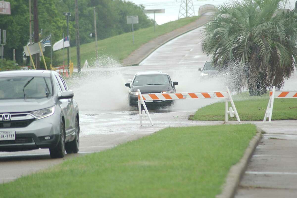 A barricade warns commuters of high water heading westbound on Scarsdale Boulevard near the Gulf Freeway during Tropical Storm Beta.