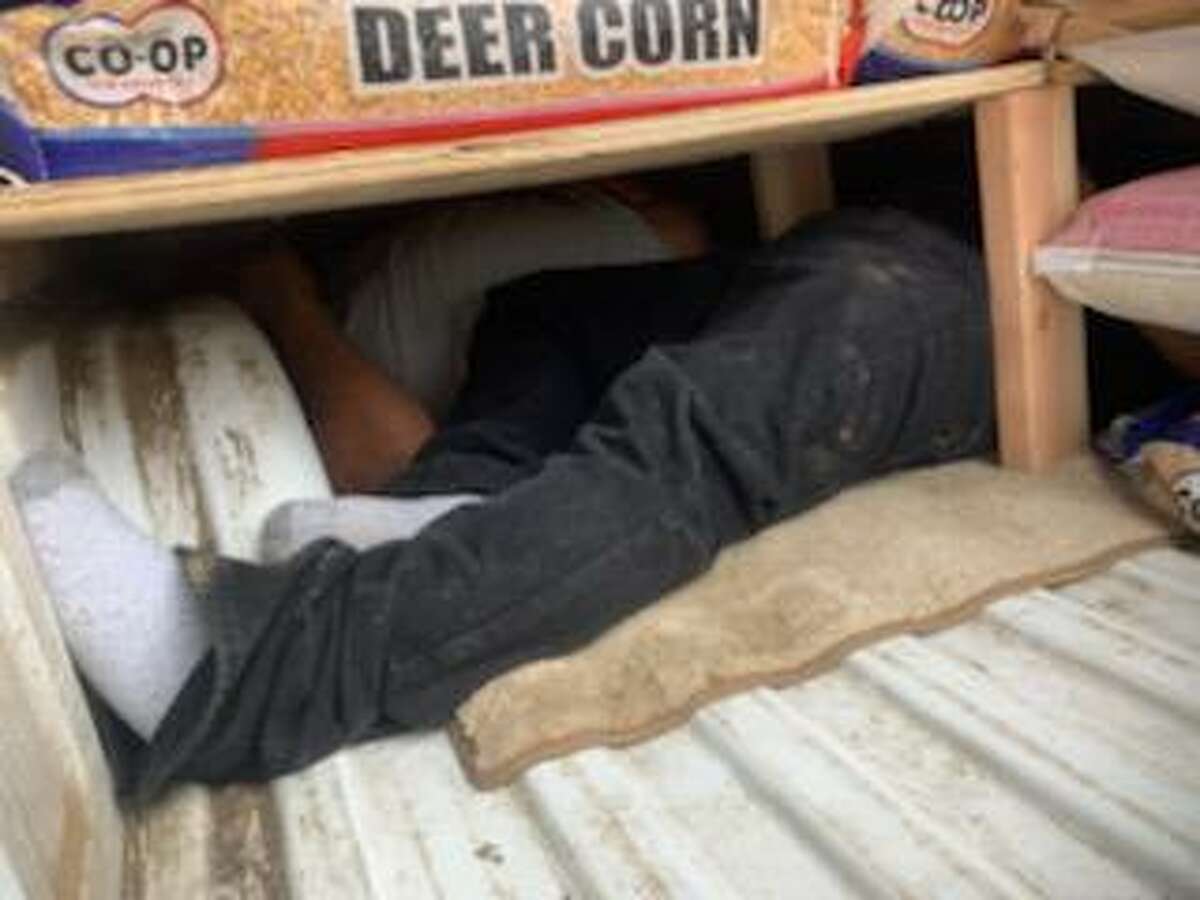 People can be seen inside a compartment that was hidden underneath bags of deer corn, horse feed and dog food. U.S. Border Patrol agents discovered four individuals who had crossed the border illegally.