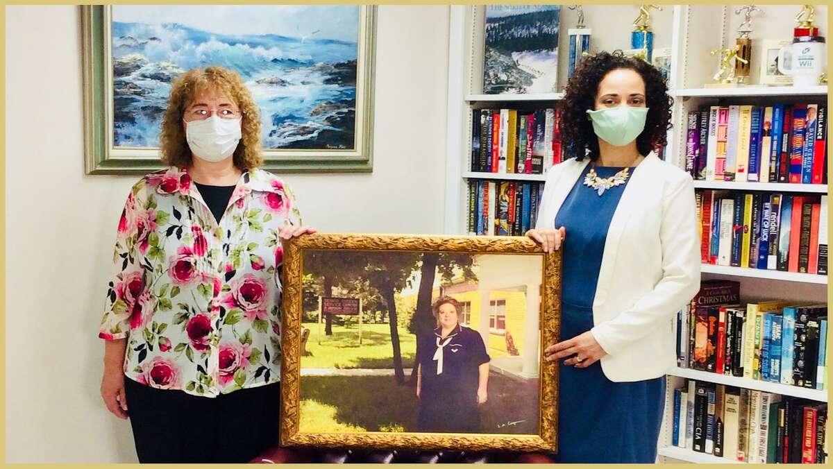 Milford Senior Center's retired executive director, Janice M. Jackson, and Leonora Rodriguez, current executive director, hold a framed photo of the center's founding director, Kathi Bissell, who died in 2004.