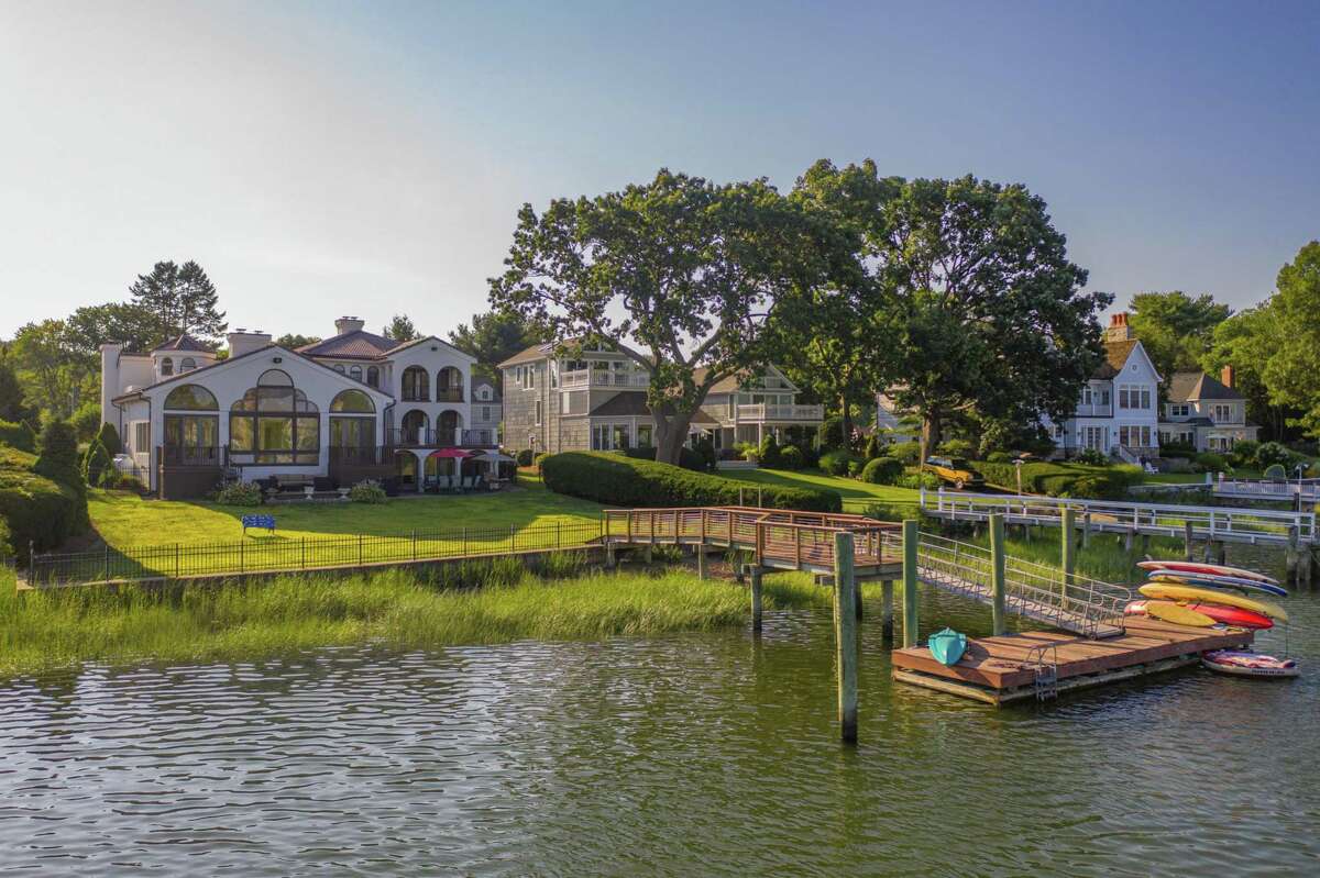 Enjoy waterfront living year-round on this property. Wide slate steps lead from the ample gravel driveway to the covered front entrance of this 10-room house; the front door opening into the two-story foyer with marble flooring, built-in seating, tall columns, archways, and an interior balcony.