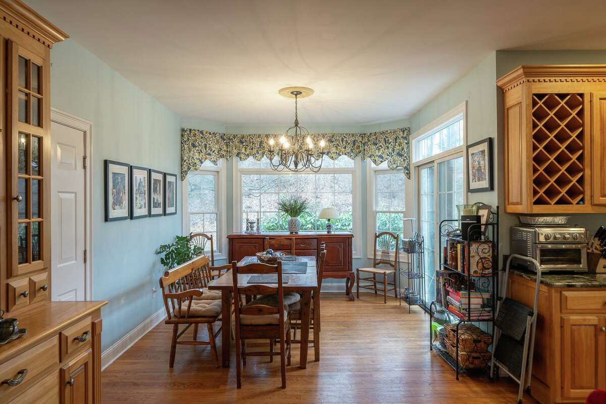 The breakfast nook has a bay window, transoms and sliding doors to the patio and backyard. In the living room there is a fireplace with a decorative mantel, dentil crown molding, and arched transoms above the windows giving the appearance of a Palladium style. These windows and the crown molding is repeated in the formal dining room, which has French doors to separate it from the spacious gourmet eat-in kitchen.