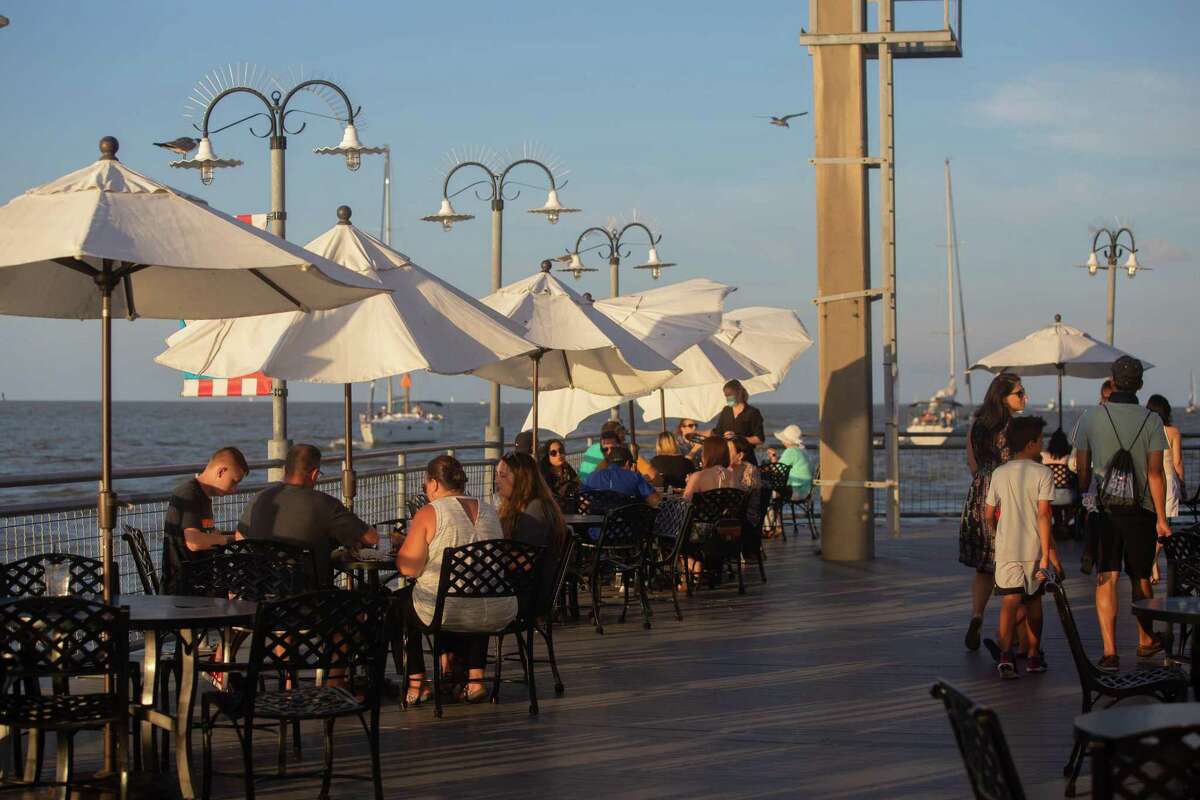Visitors enjoy the dine by the water at the Kemah Boardwalk in July. The Greater Houston Partnership’s Patrick Jankowski will explore what industries are closest to full recovery and which have a long way to go at an economic update webinar on Monday.