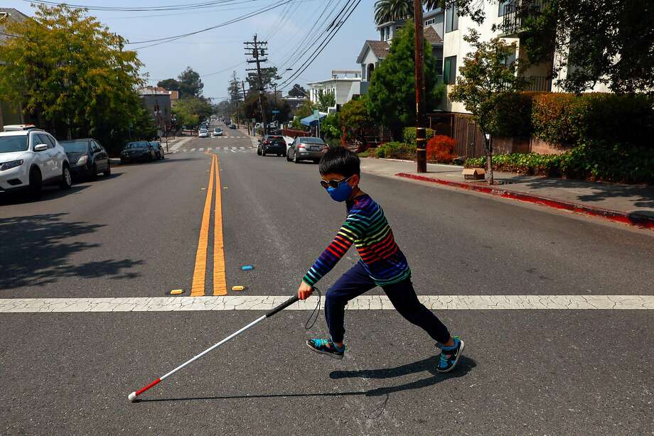 Kai Wang, 7, who is legally blind from retinal degeneration, runs across the street in Berkeley on an outing with his family during a break from distance learning. Photo: Gabrielle Lurie / The Chronicle
