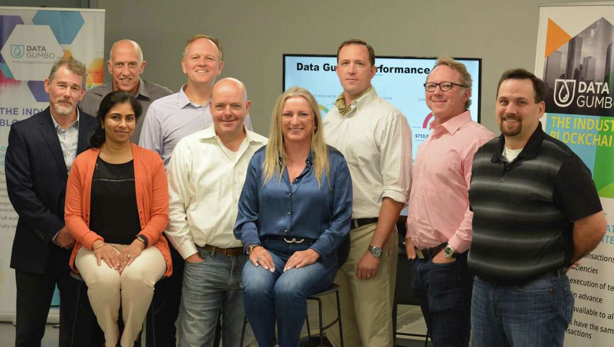 Data Gumbo CEO Andrew Bruce, second from left in the front, poses with his employees at a trade event.