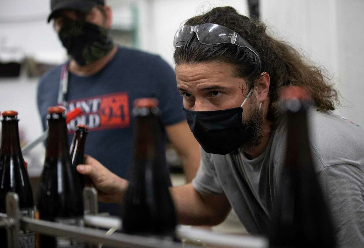 Saint Arnold Brewing Company Packaging Team Leader Josh Day performs quality check on the "Black Is Beautiful" beer Tuesday, Sept. 8, 2020, in Houston. The Black Is Beautiful beer is a limited charity beer that will benefit Fifth Ward Community Redevelopment Corporation.