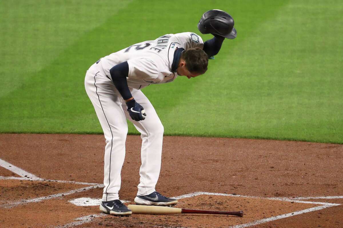 SEATTLE, WASHINGTON - SEPTEMBER 23: Evan White #12 of the Seattle Mariners slams his helmet after striking out to end the first inning against the Houston Astros at T-Mobile Park on September 23, 2020 in Seattle, Washington.