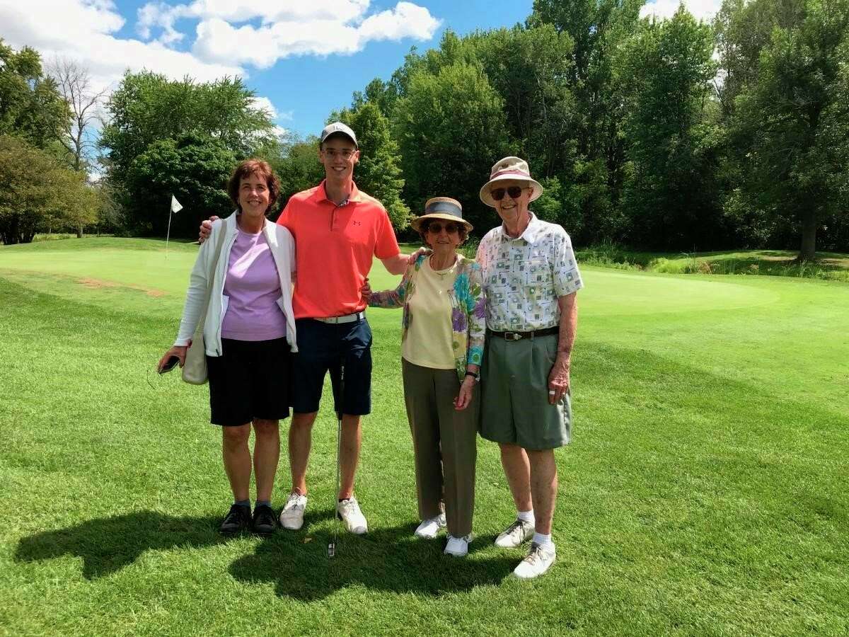 Ted Broadwell (far right) and his family -- (from left) daughter Julie Holmes, grandson Eric Holmes, and wife Barb -- pose for a picture near the 18th green after Broadwell recently shot his age or better for the 1,000th time at Currie Municipal Golf Course. (photo provided)