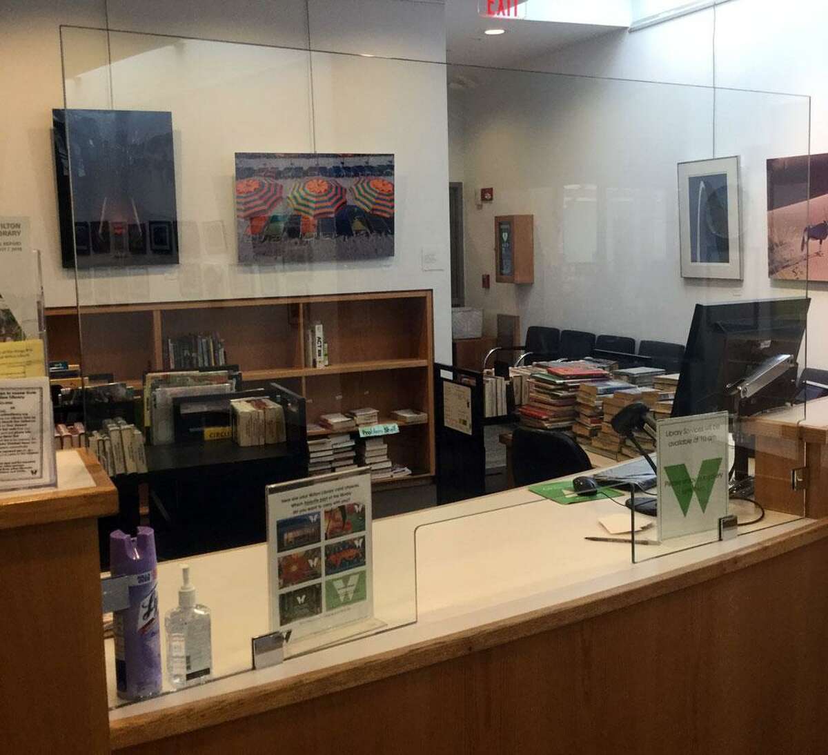 Wilton Library is opening its building to patrons for in-person express service appointments only beginning Monday, Sept. 28. Pictured: The library’s reconfigured circulation desk with protective glass shields for patron and staff safety.