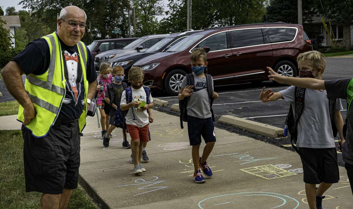 Bo Jarabak watches Glen Carbon Elementary students wave and wish him a happy retirement after dismissal on Wednesday.