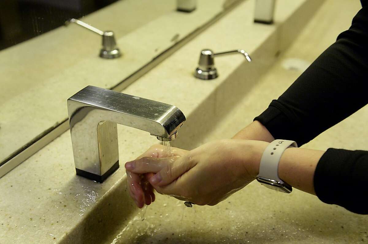 Molly Lacob washes her hands in one of the few public restrooms in the Ferry Building during a trip to the Ferry Plaza Farmers Market on Saturday, August 8, 2020, in San Francisco, Calif. Shoppers, many of whom are reluctant to use public restrooms due to the coronavirus, said they prepare for not using a public restroom before venturing to the market, and although there's talk of porta potties near the building, none are in place as of yet.