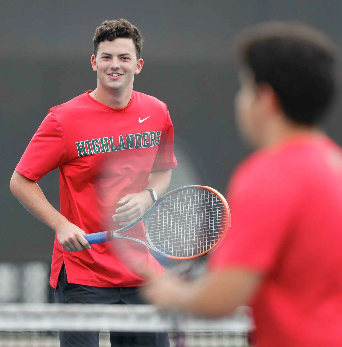 The Woodlands’ Caleb Gills shares a laugh as he warms up before a high school tennis match at Grand Oaks High School, Thursday, Sept. 24, 2020, in Spring.