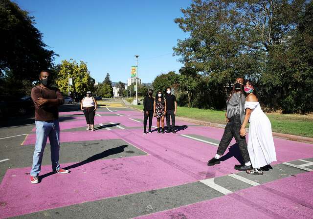 Left to right: Derrick Bell, Sen Mendez, Kin Folkz, Imani Smith, Nkosi Smith, Fiera Ferrari and Bash Baby Blue pose at the Lake Merritt All Black Lives Matter mural in Oakland. Other BLM muralists and designers who weren't present for the photo are Aala Oni, Aika Eden, Guerrilla Davis, Kahalla, Olivia Ramos, Sasha Kelley, Vee Vee, Violet Batista and Janetta Johnson. More than 300 volunteers helped paint the mural.