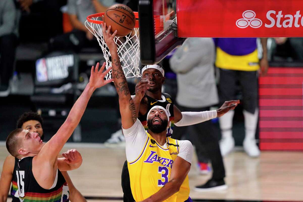 Los Angeles Lakers' Anthony Davis (3) shoots against Denver Nuggets' Nikola Jokic (15) during the first half of an NBA conference final playoff basketball game Thursday, Sept. 24, 2020, in Lake Buena Vista, Fla. (AP Photo/Mark J. Terrill)