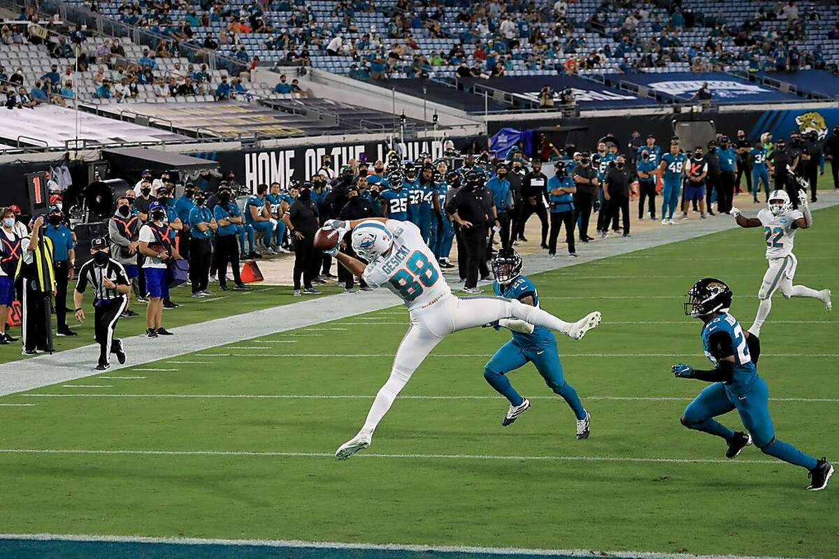 Miami’s Mike Gesicki contorts his body for a touchdown reception from quarterback Ryan Fitzpatrick (not pictured) against the Jaguars in Jacksonville, Fla., on Thursday night.