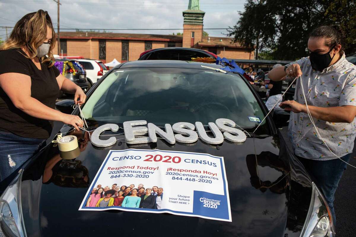 Nicole Duran, left, and her partner Melissa Allala decorate their car for the Census Bureau’s vehicle parade in Third Ward on Sept. 19, 2020.