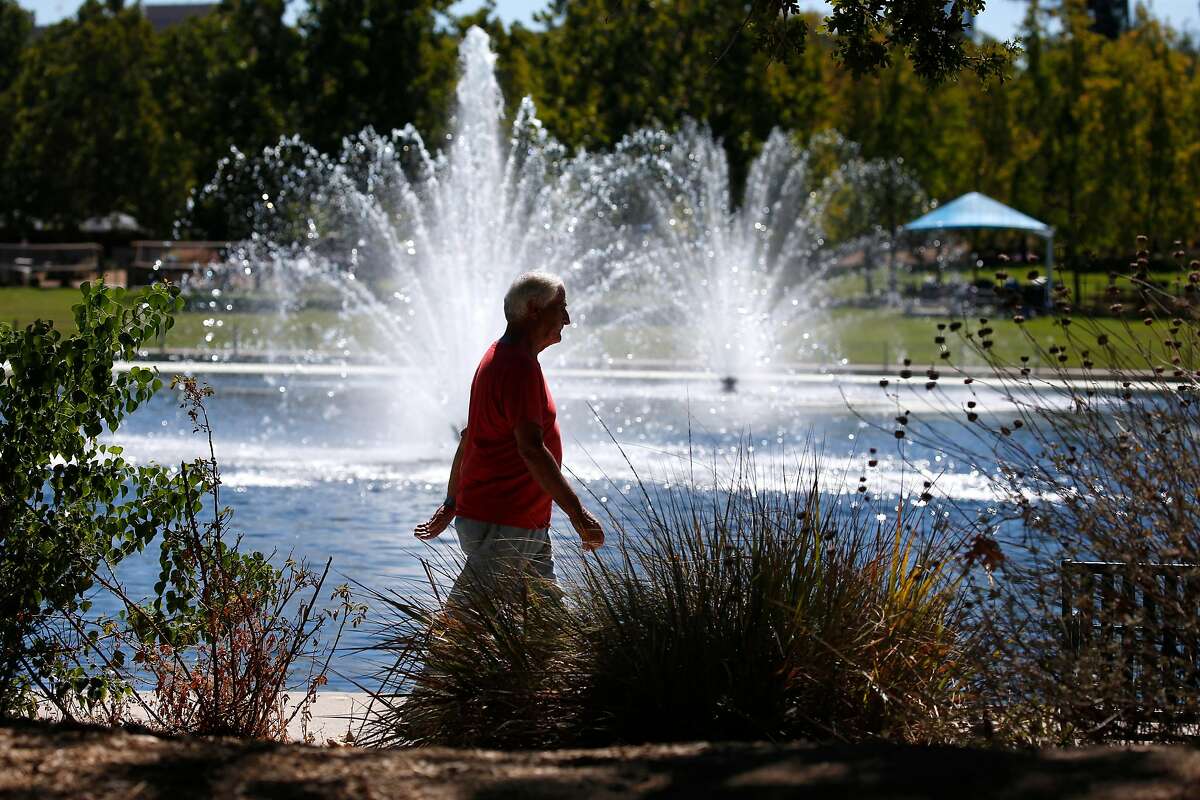 2020年9月24日，一名男子在加利福尼亚州核桃溪的希瑟农场公园绕湖散步。本周末，另一股热浪预计将席卷湾区。登录必赢亚洲