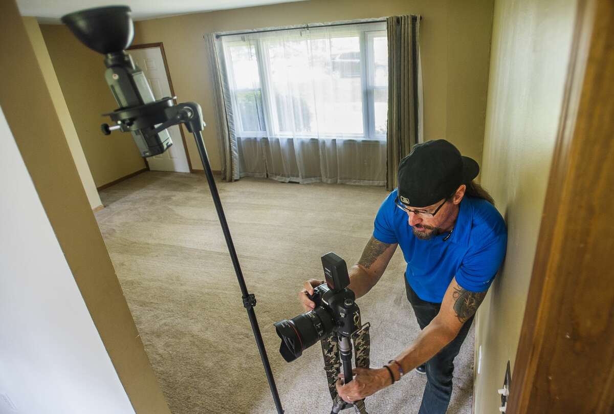 Real estate and freelance photographer Doug Julian photographs a home for sale at 1017 W. Marsh Road near Sanford Lake Wednesday in Sanford. (Katy Kildee/kkildee@mdn.net)