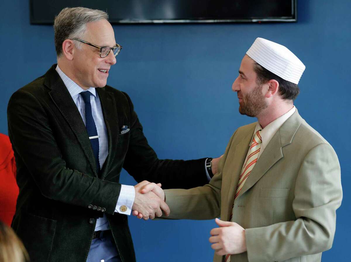 Rabbi Edwin Goldberg, with Congregation Beth Shalom of The Woodlands, left, shakes hands with Imam Rihabi Mohamed, with the Islamic Center of The Woodlands, during Break Bread and Boundaries at Lama Cafe, Wednesday, Jan. 29, 2020, in Shenandoah. Since the COVID-19 pandemic hit the area, the synagogue has been closed but services have been streamed online. For the High Holy Days, Goldberg said Beth Shalom will continue streaming services, and reminds congregants that the mercy they pray for should be given to themselves during these difficult times as well.